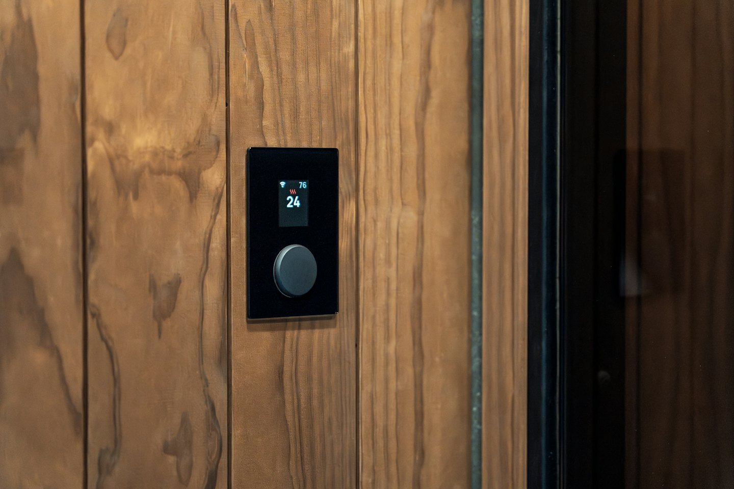 Smart-Home-Bedienfeld an einer Holzwand mit Temperaturanzeige.
